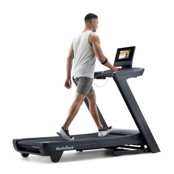 Sportuojantis žmogus ant NordicTrack Commercial 1250 bėgimo takelio